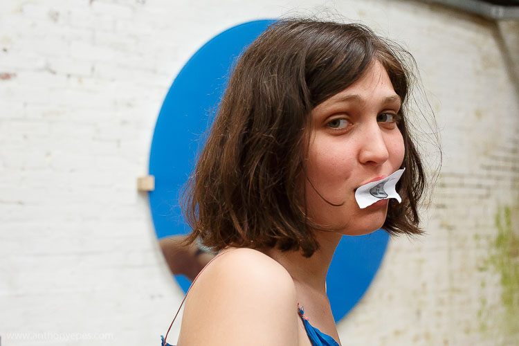 woman with paper in mouth street portrait photography