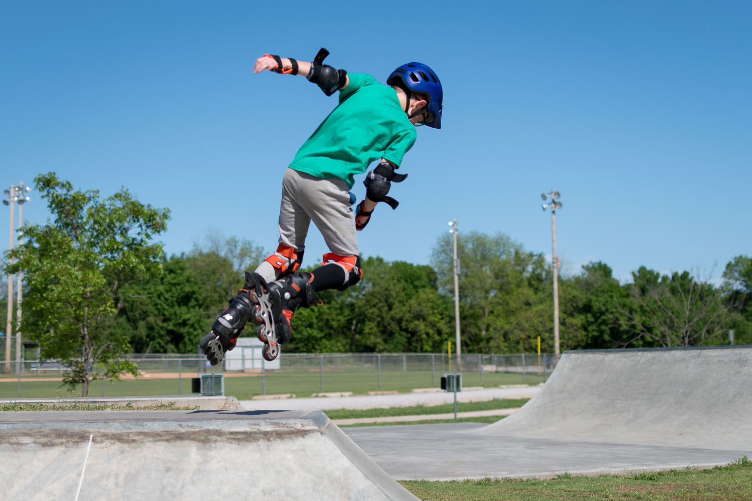 JPEG vs HEIC: A child on rollerblades jumping over a ramp.