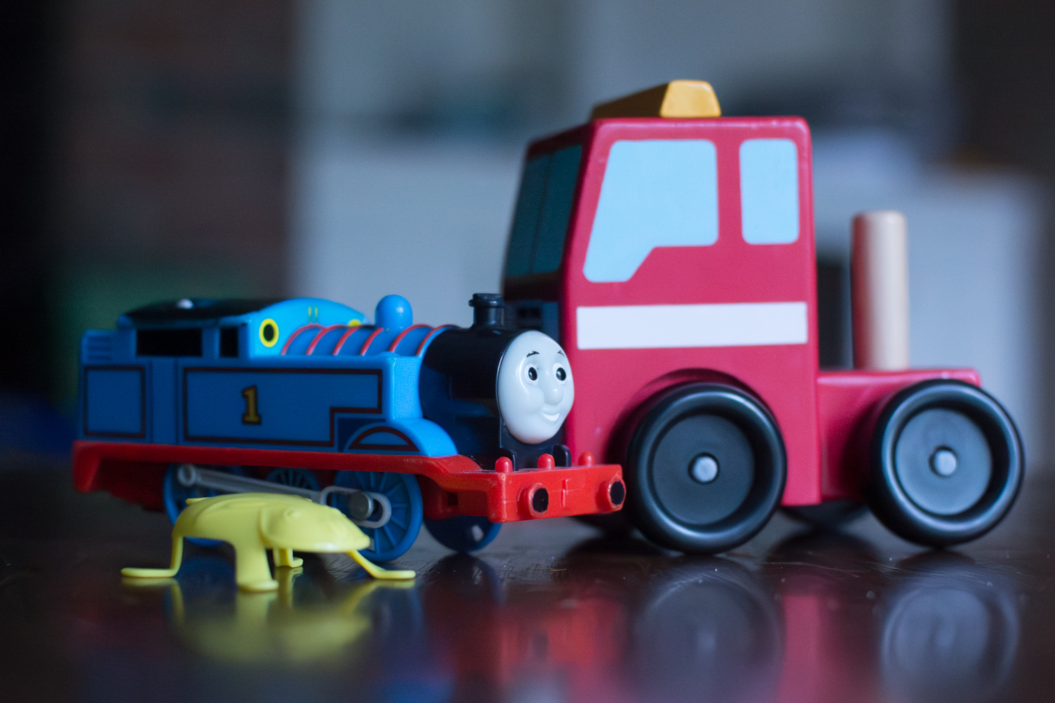 Lightroom's AI-Powered Denoise Feature: toy train and truck on a table surface.