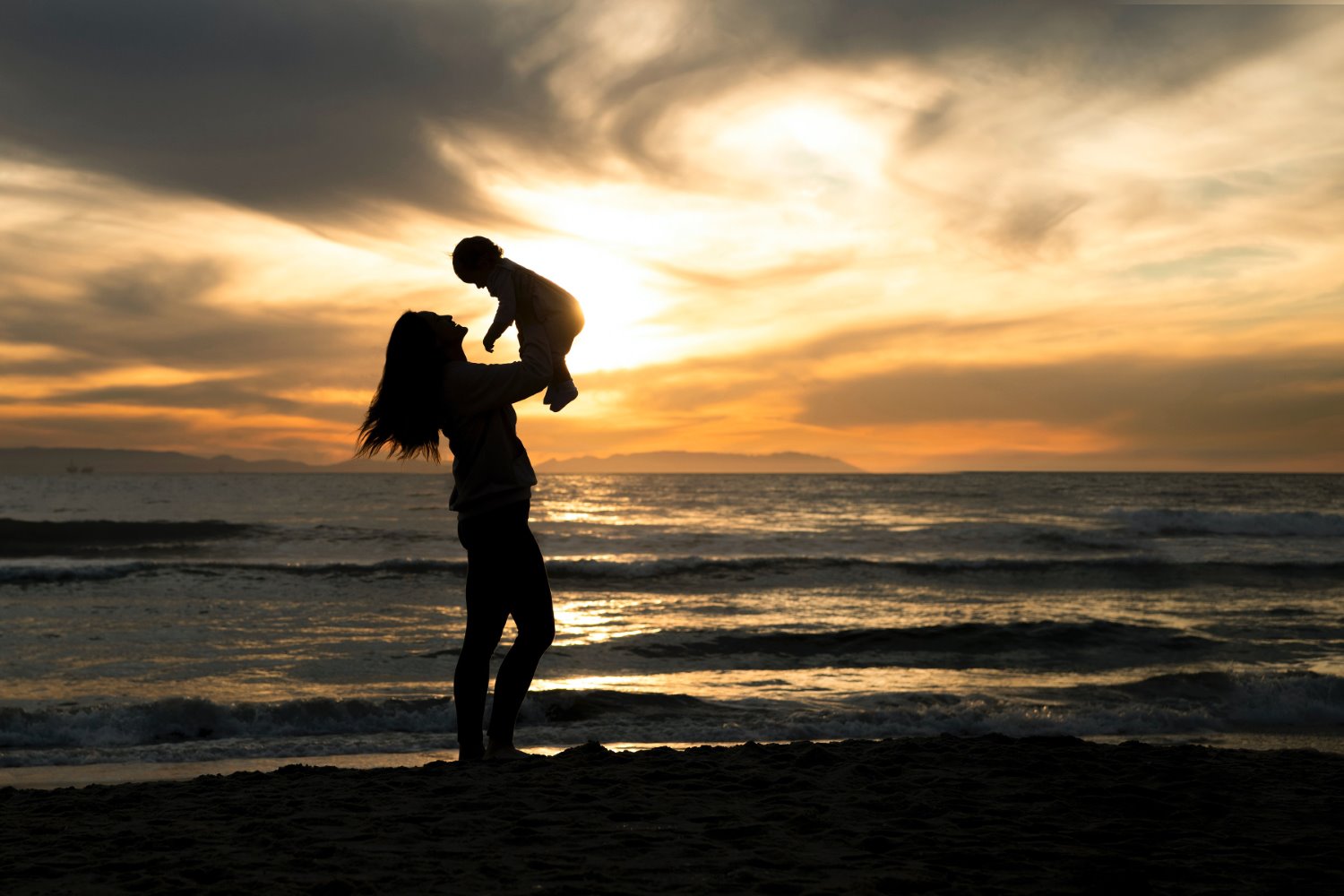 silhouette photography of a person holding a child