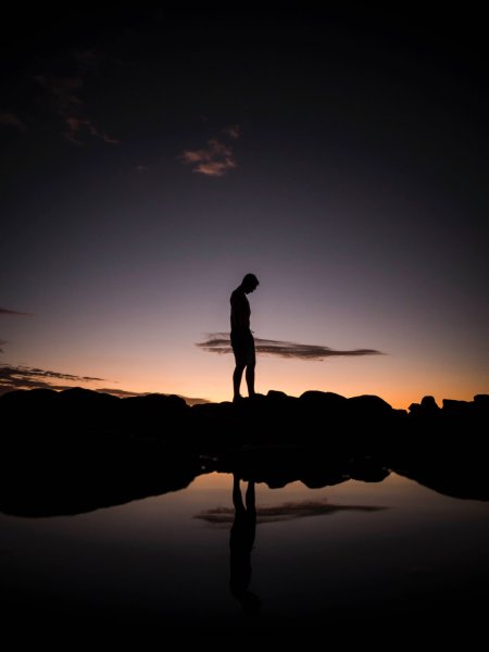 silhouette photography man standing on a rock